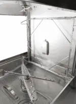 Interior of hood style pass through dishwasher with stainless steel interior and dual spray arms